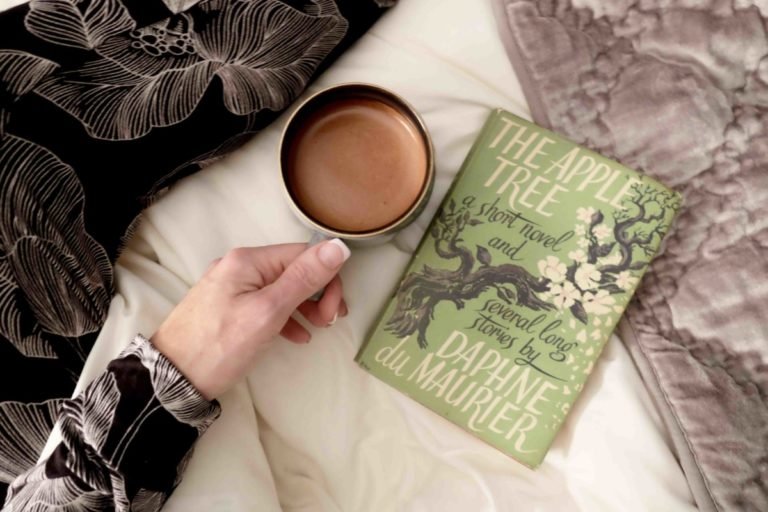 a hand sit with a cosy book and a coffee and relax