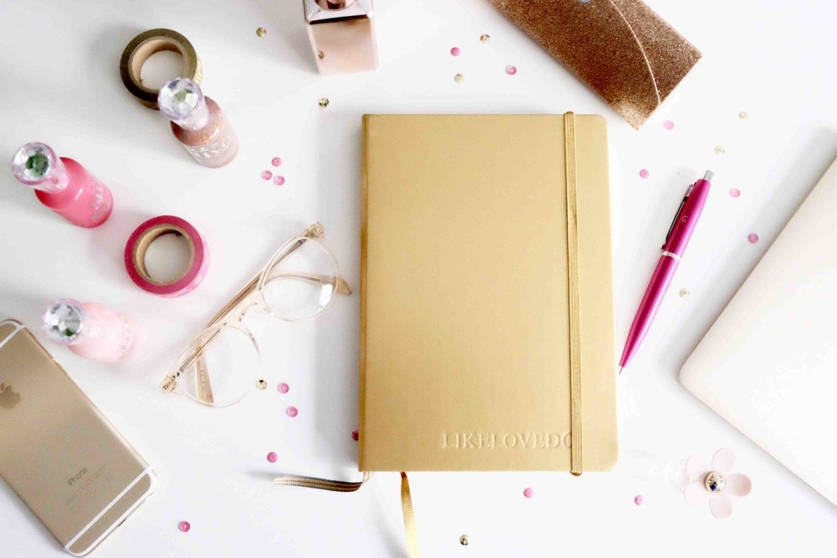 desk space flat lay pink gold glitter embossed leather journal