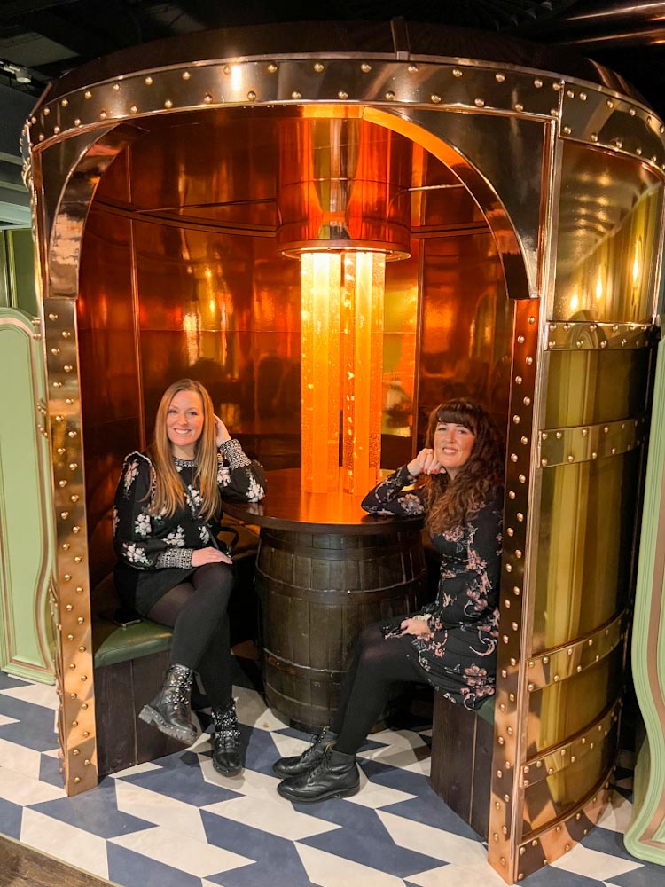 Sitting in a beer Vat or a beer barrel and drink butter beer at the Harry Potter photographic exhibit London