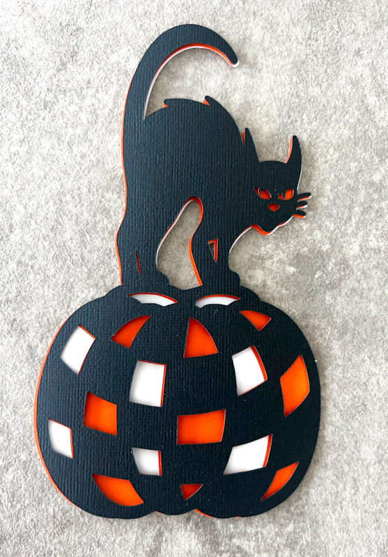 Free 3 layer Halloween Cat svg on a checkered pumpkin Close up in card