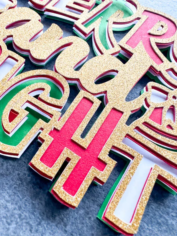Close up of Free Layered Merry and Bright SVG cut in card and glitter for crafting Cricut and Silhouette cameo