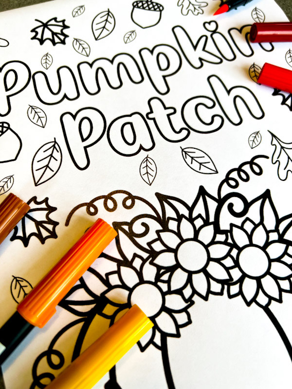Pumpkin pile coloring page with fall leaves, sunflowers and acorns to color in
