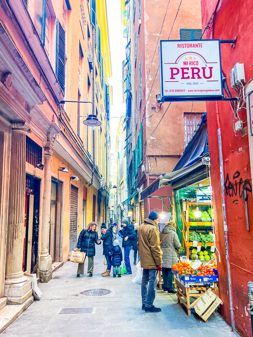 peolp shopping at a fruit stall in Sides street in Genoa