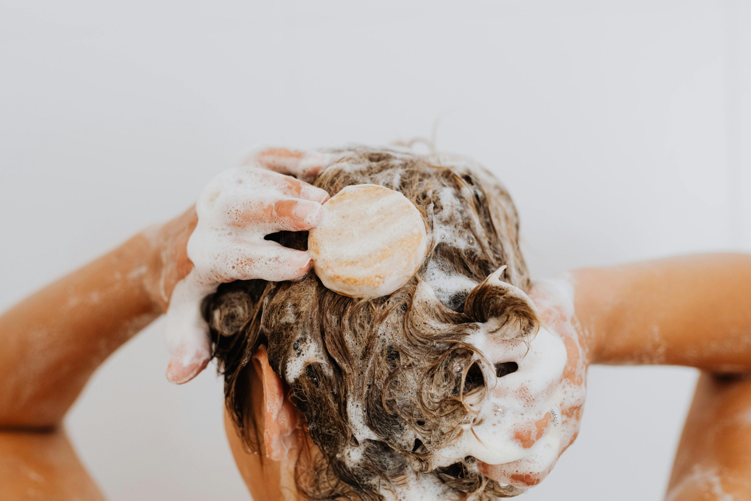 Woman washing hair with soap