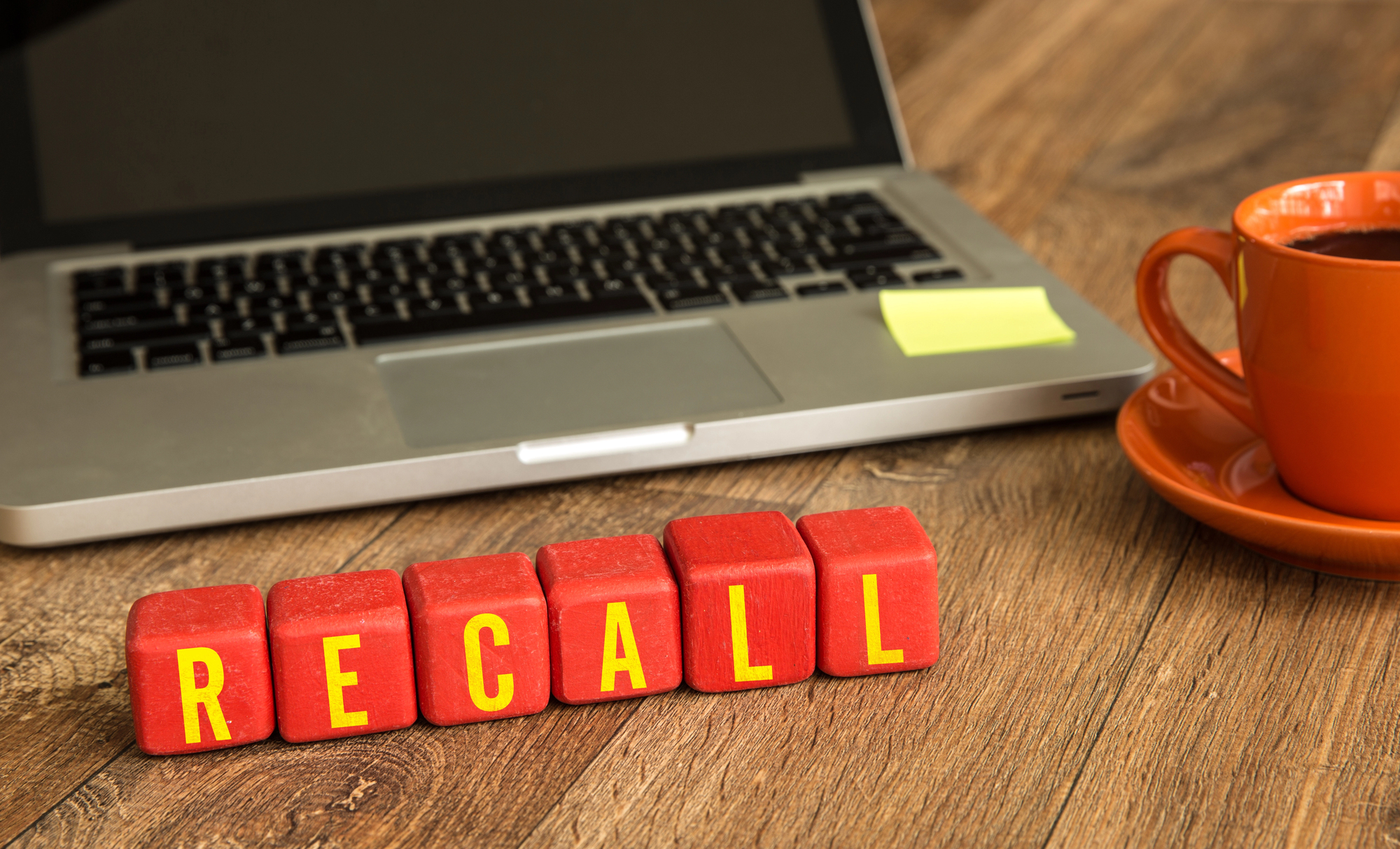 A computer postit note and word saying recall